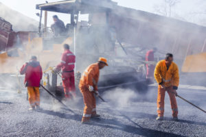 workers with truck behind dust